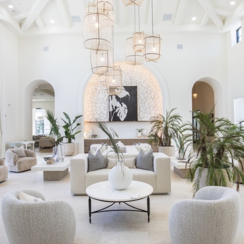 a naturally lit lounge with white chairs