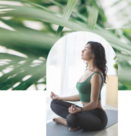 woman meditating alongside palm leaves at Fiori in Naples, Florida