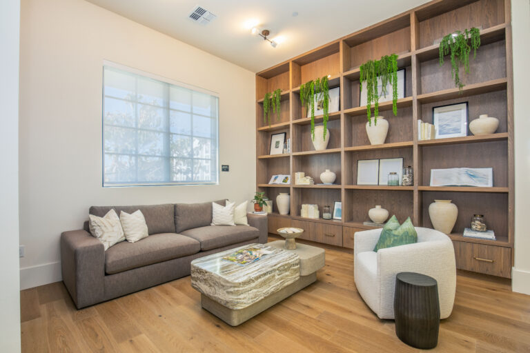 Stylish lounge with bookshelf and seating at Fiori Apartments